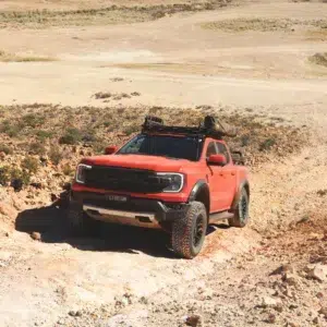 Red Ford Ranger driving along a rocky off-road track