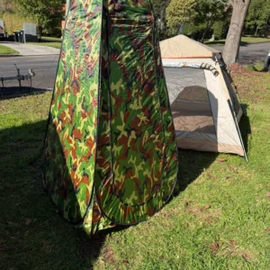 Portable shower tent set up beside camping tent for a complete campsite setup